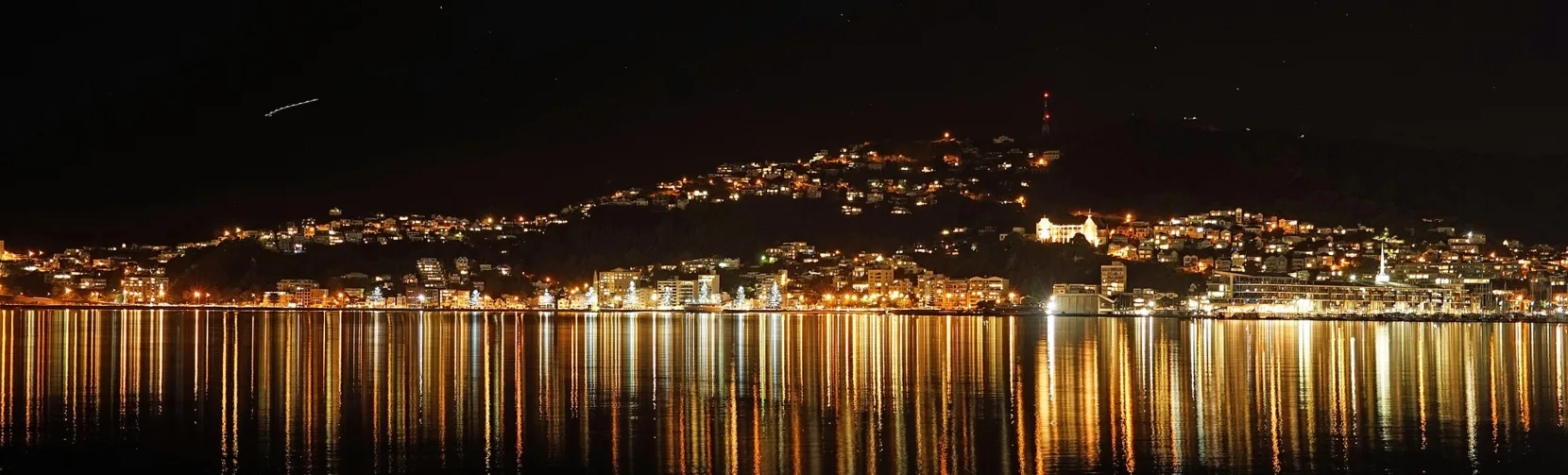 Night view of Wellington Harbour with city lights reflecting on the water in New Zealand’s capital city