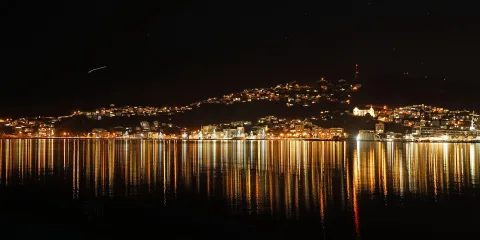 Night view of Wellington Harbour with city lights reflecting on the water in New Zealand’s capital city