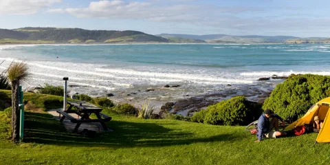 Camping by the beach at Curio Bay Tumu Toka with ocean waves, picnic area and coastal scenery in the Catlins, Southland New Zealand
