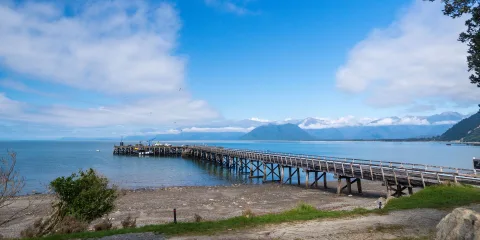 Wooden wharf stretching into the sea at Jackson Bay, a small fishing port near Haast on the West Coast of New Zealand’s South Island