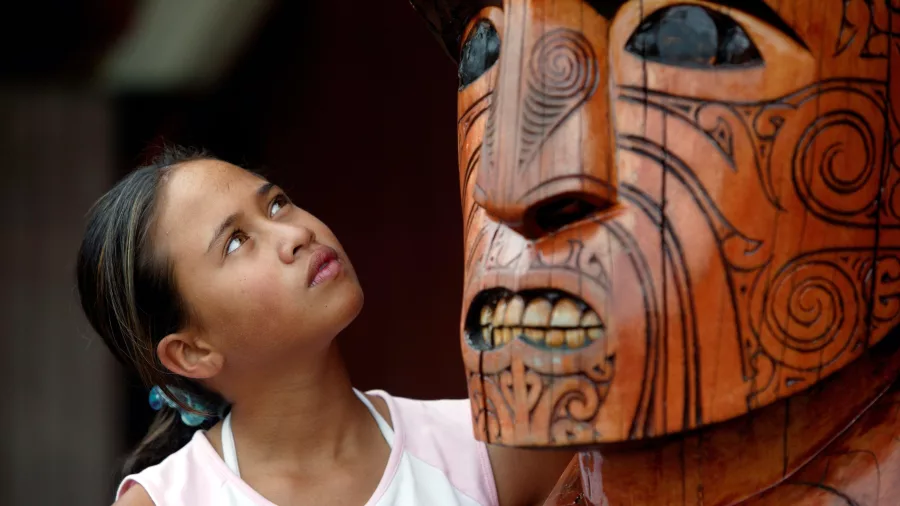 Child looking at Māori carving in Auckland