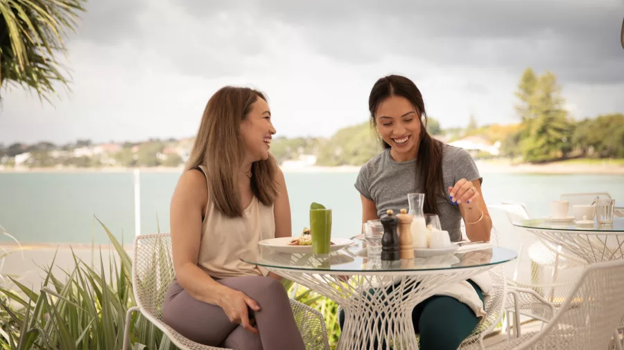 Women enjoying breakfast at waterfront cafe