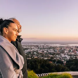 Couple admiring Auckland city from Mount Eden