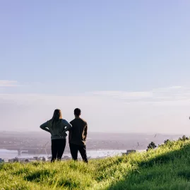 Couple admiring Auckland city view from Mount Eden