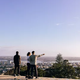 Group viewing Auckland city skyline from Mount Eden