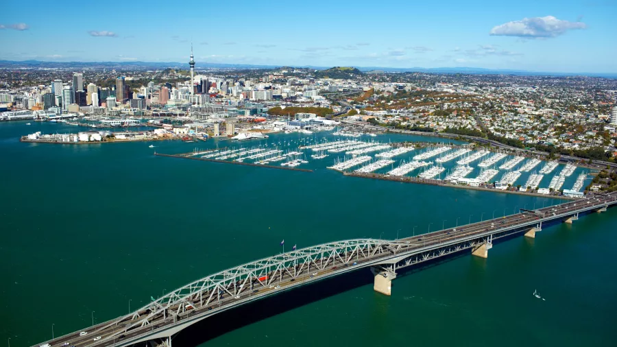Aerial view of Auckland Harbour Bridge with city skyline and marina in the background