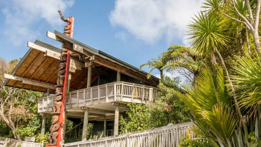 Arataki Visitor Centre with Māori carving and native bush in Waitākere Ranges