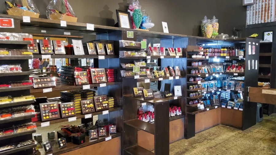 Ledges stocked with colourful jars and bags of artisanal vintage sweets and chocolates in a boutique Matakana confectionery shop, New Zealand