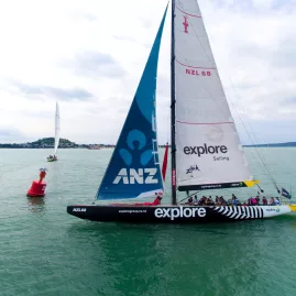 The America's Cup yacht NZL68 sailing past a race marker during a competitive match race
