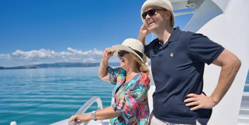 Two passengers enjoying sea views from the outdoor deck of a Waiheke Island ferry.