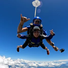 12-year-old Conor tandem skydiving high above Auckland’s scenic landscape
