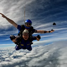 Tandem skydive above the clouds with blue sky and adrenaline-filled excitement