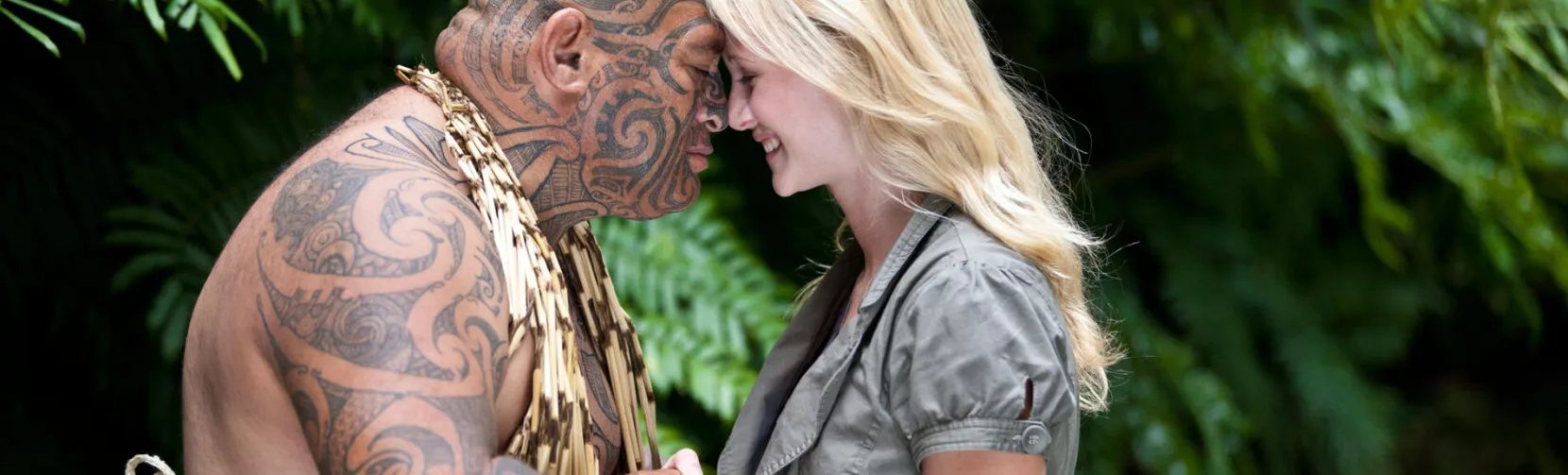 Māori man and visitor sharing a traditional hongi greeting in native forest setting