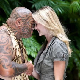 Māori man and visitor sharing a traditional hongi greeting in native forest setting
