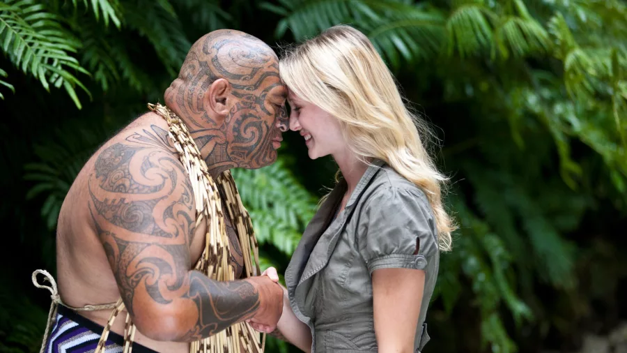 Māori man and visitor sharing a traditional hongi greeting in native forest setting