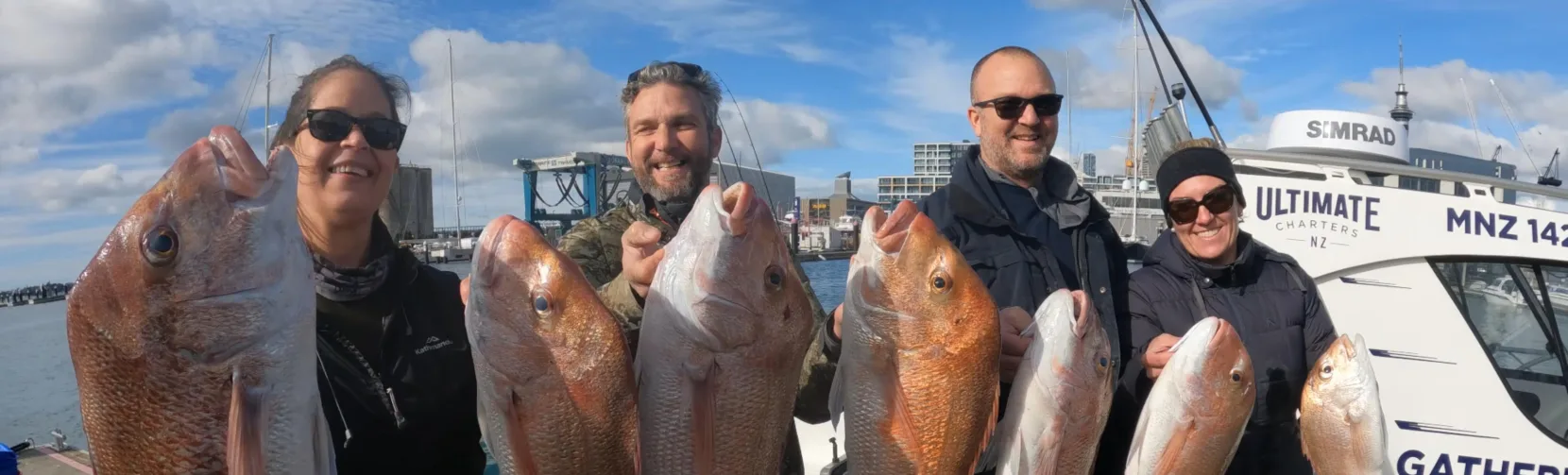 Group of anglers holding large snapper catch at Auckland marina
