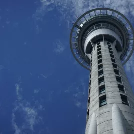 Auckland Sky Tower against a blue sky, iconic city landmark featured in Auckland coastal tours
