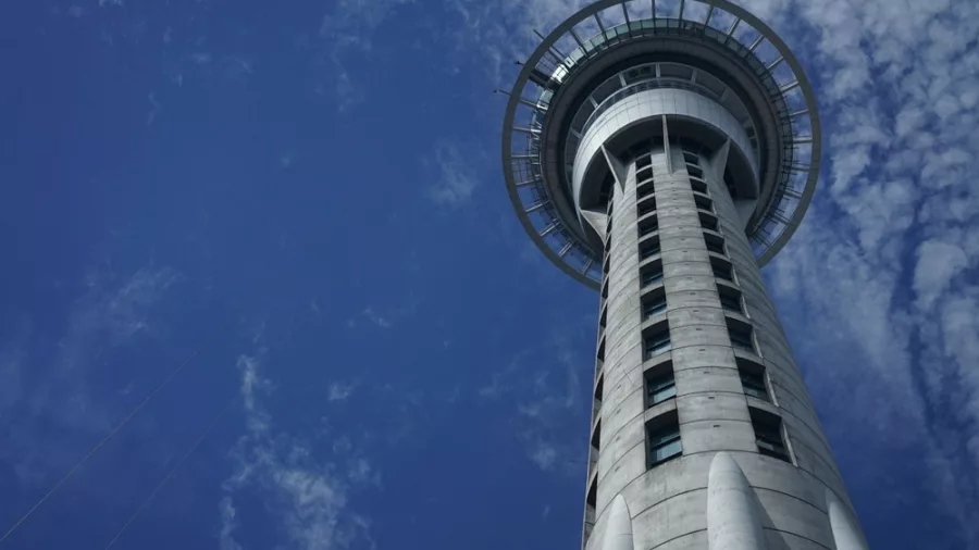 Auckland Sky Tower against a blue sky, iconic city landmark featured in Auckland coastal tours