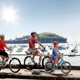 Family cycling along Tamaki Drive in Auckland