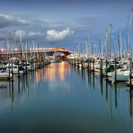 Auckland Harbour Bridge and Westhaven Marina at sunset with moored yachts