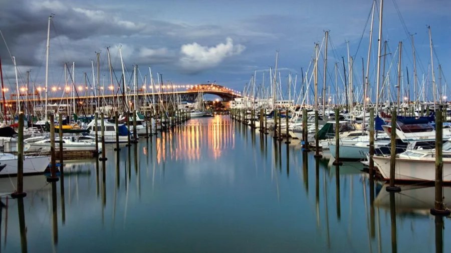 Auckland Harbour Bridge and Westhaven Marina at sunset with moored yachts