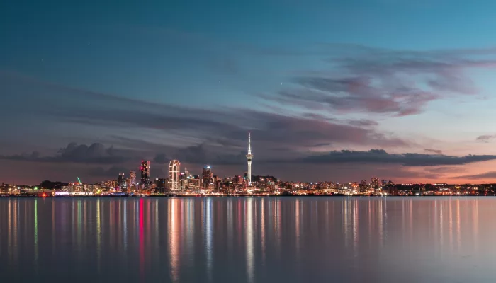Auckland city skyline with Sky Tower and harbour lights at dusk, North Island, New Zealand.