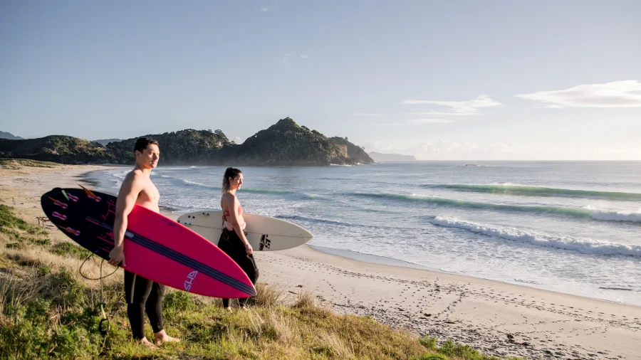 Couple with surfboards at Medlands Beach Great Barrier Island