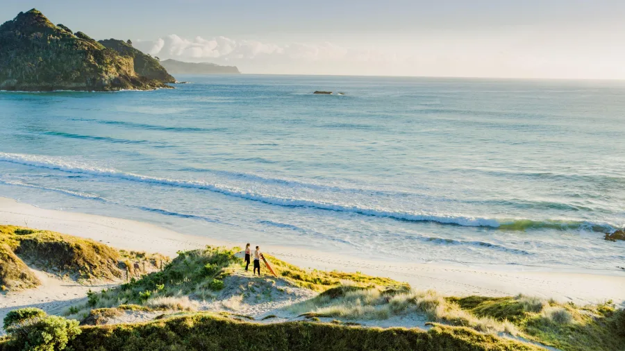 Surfers walking on Medlands Beach Great Barrier Island