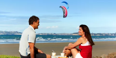 Couple eating fish and chips at Orewa Beach