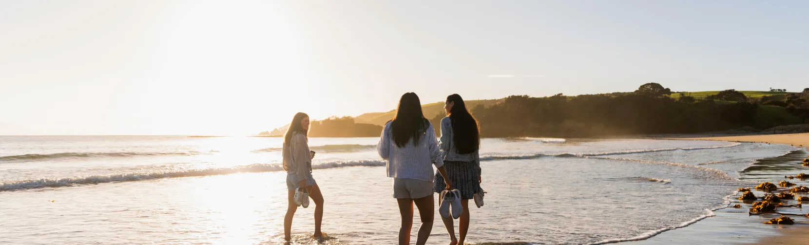 Three women on beach at Tawharanui Regional Park, Matakana