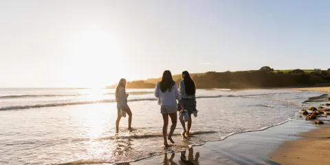 Three women on beach at Tawharanui Regional Park, Matakana