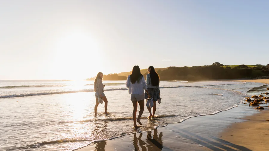Three women on beach at Tawharanui Regional Park, Matakana