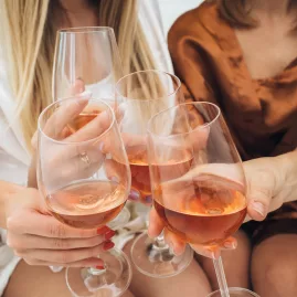 Close-up of a group of friends clinking glasses of rosé wine in a joyful celebration, showcasing a moment of connection and elegance.