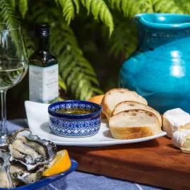 A shared food and wine experience featuring a beautifully arranged table with gourmet platters, local wines, and relaxed outdoor ambiance.