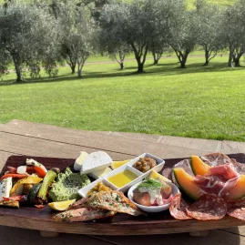 Gourmet tasting platter with cured meats, cheeses, vegetables, and bread at Stonyridge Vineyard during Waiheke Island food and wine tour