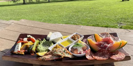 Gourmet tasting platter with cured meats, cheeses, vegetables, and bread at Stonyridge Vineyard during Waiheke Island food and wine tour