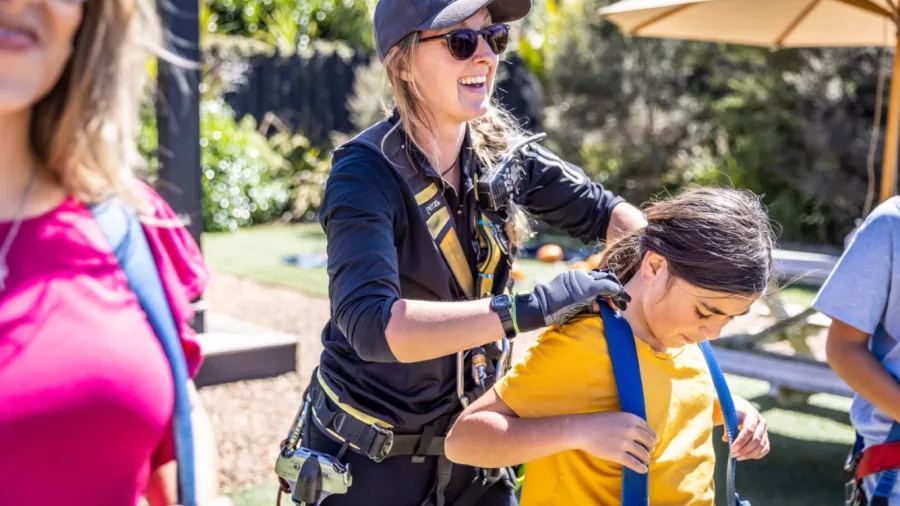 EcoZip guide helps child prepare for zipline adventure over Waiheke Island’s native forest and vineyards