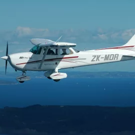 Light aircraft flying above the Hauraki Gulf near Rangitoto Island and Auckland, en route to Waiheke Island for a premium vineyard lunch and wine tasting tour