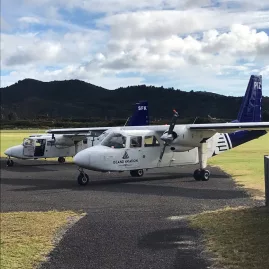 BN-2 Islander and Cessna aircraft parked at Waiheke Island airfield, ready for extended scenic flights and premium wine tours with Island Aviation