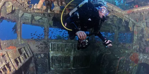 Scuba diver exploring the interior of HMNZS Canterbury shipwreck on NZ Diving Charter in New Zealand