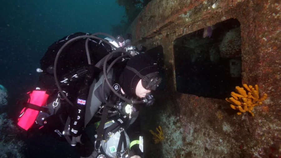 Scuba diver exploring the hull of the Rainbow Warrior shipwreck during a New Zealand Diving charter at Matauri Bay, Cavalli Islands.