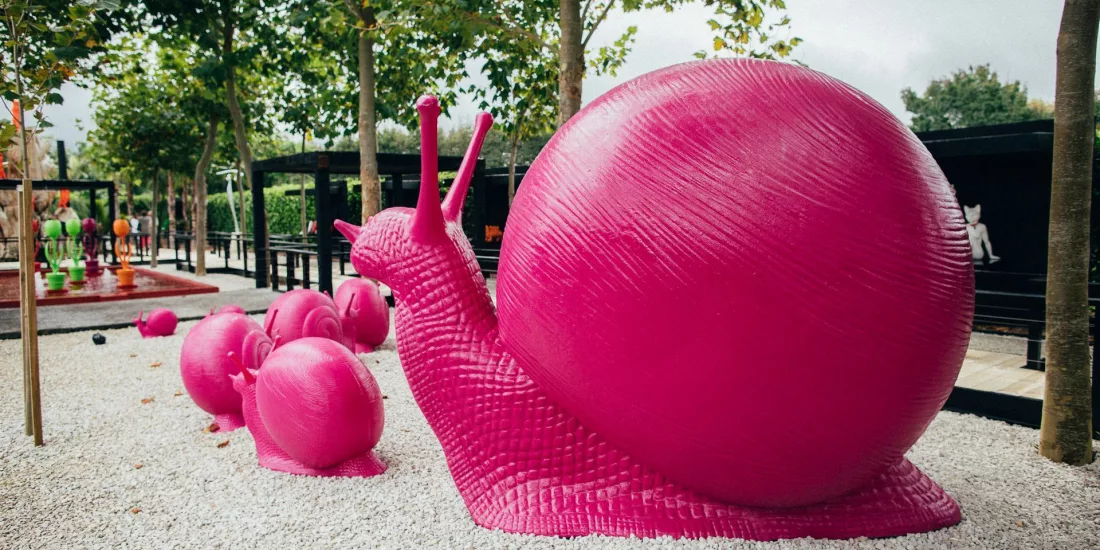 Large pink snail sculptures featured in the outdoor art gardens at Sculptureum, Matakana, New Zealand.