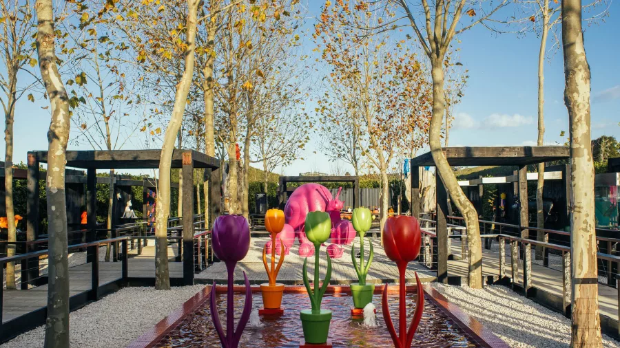 Vibrant tulip-like sculptures in different colors displayed in the reflecting pool at Sculptureum gardens, Matakana, New Zealand.