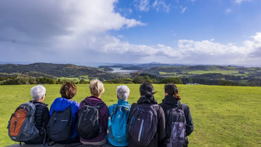 Walker on a private Te Ara Hura track surrounded by lush native bush on Waiheke Island