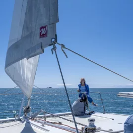 Elegant yacht sailing along the coast during a Hauraki Gulf sailing experience