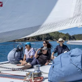 Sailing yacht cruising through calm waters with scenic coastal views from Waiheke Island