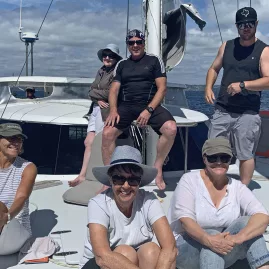 Yacht sailing across calm blue waters under clear skies