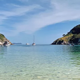 Tranquil bay with anchored sailing yacht surrounded by a sheltered bay