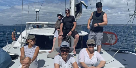 Yacht sailing across calm blue waters under clear skies