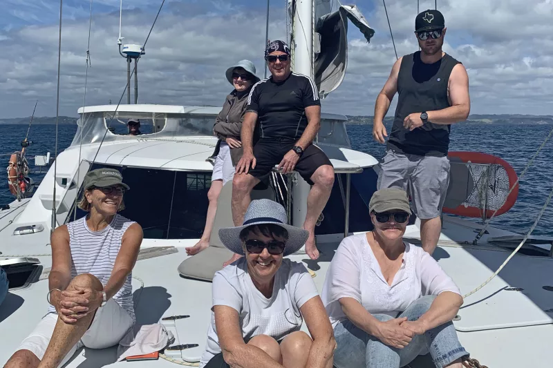 Yacht sailing across calm blue waters under clear skies